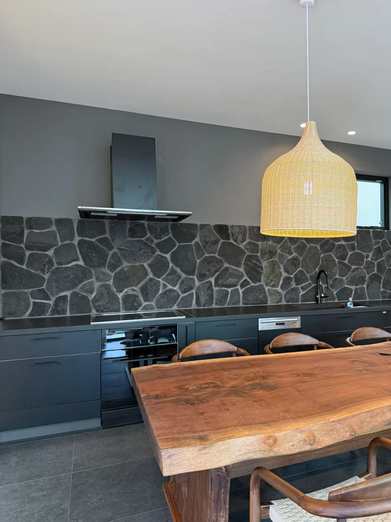 「黒い石貼り壁と造作キッチンが特徴の上質なダイニングキッチン|湘南の高級注文建築」