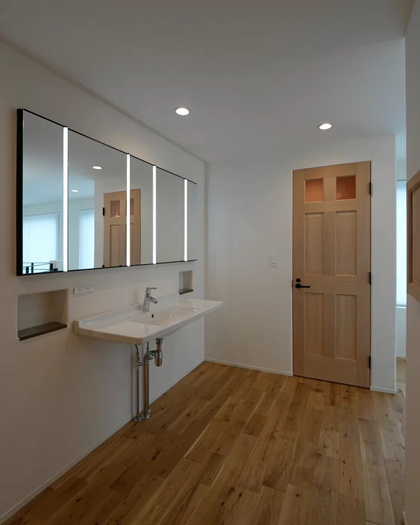 「造作ミラーとワイド洗面カウンターが特徴の上質なサニタリールーム|鎌倉の注文住宅」